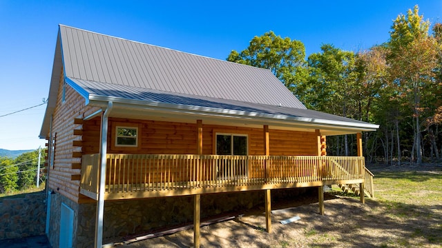 rear view of house featuring a wooden deck