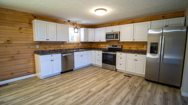 kitchen with sink, white cabinets, stainless steel appliances, and light wood-type flooring