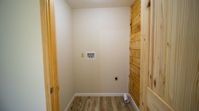 laundry area with washer hookup, electric dryer hookup, light wood-type flooring, and a textured ceiling