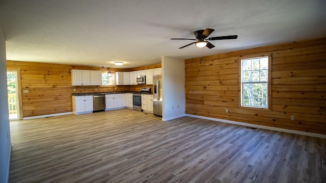 kitchen featuring white cabinetry, plenty of natural light, stainless steel appliances, and hardwood / wood-style flooring