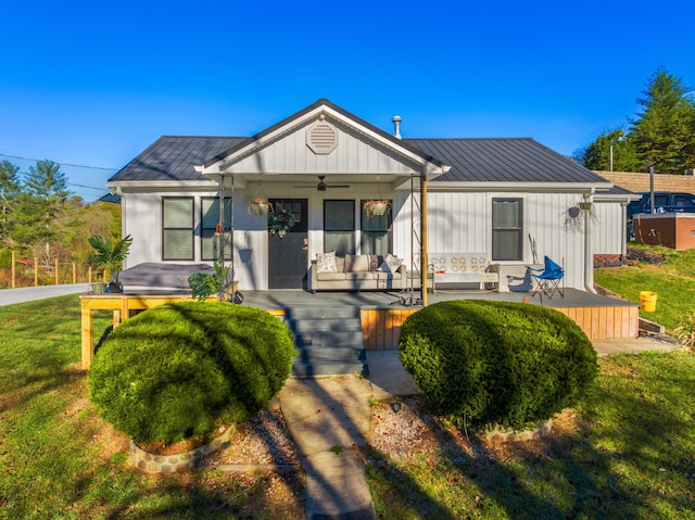 view of front of property with ceiling fan, covered porch, and a front yard