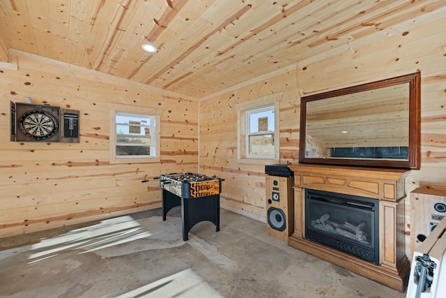 playroom featuring a healthy amount of sunlight, wooden walls, concrete floors, and wooden ceiling