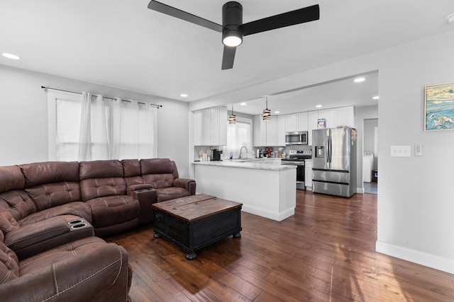 living room with ceiling fan, dark wood-type flooring, and sink