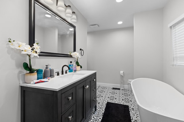 bathroom featuring a bathtub, vanity, and tile patterned flooring