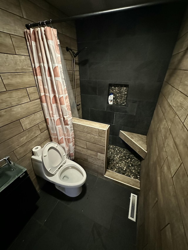 bathroom featuring tile patterned floors, curtained shower, and toilet