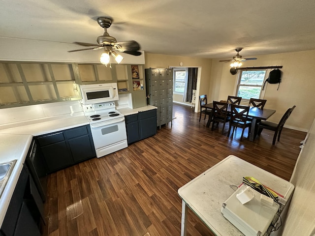 kitchen featuring dark hardwood / wood-style flooring, white appliances, and ceiling fan