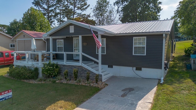 view of front facade featuring a front yard, metal roof, and covered porch