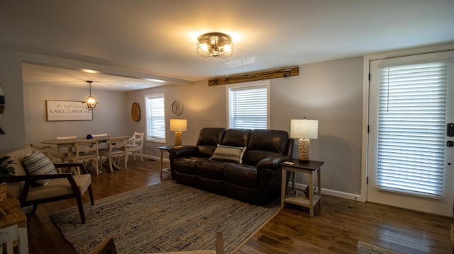 living room with a chandelier, wood finished floors, visible vents, and baseboards