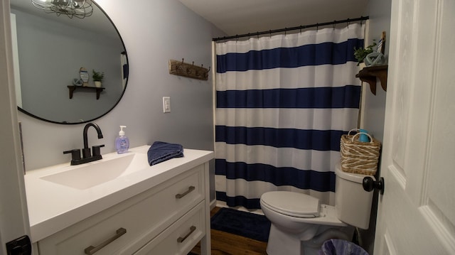 full bath with a shower with curtain, wood finished floors, vanity, and toilet