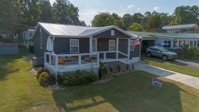 bungalow with concrete driveway, covered porch, a front yard, and metal roof