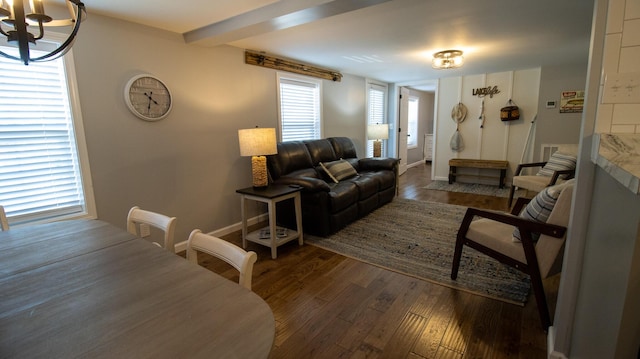 living area with baseboards, wood finished floors, and an inviting chandelier