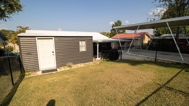 rear view of house featuring a fenced backyard, an outbuilding, and a yard