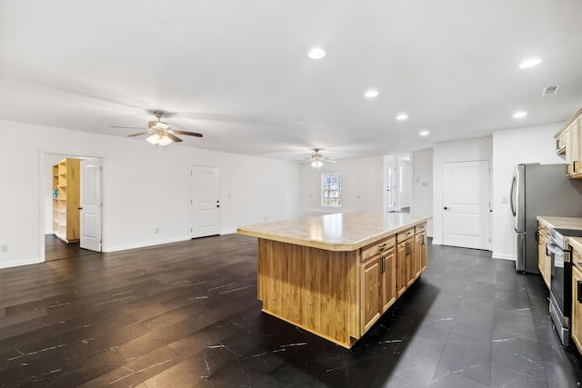 kitchen featuring ceiling fan, a kitchen island, and stainless steel appliances