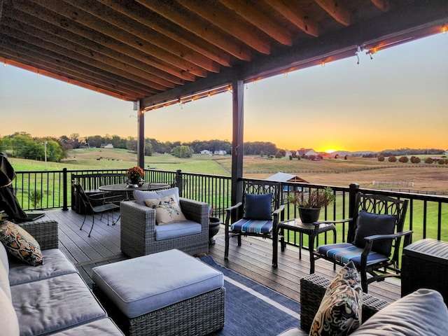 deck at dusk featuring a rural view