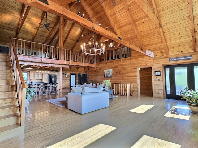 unfurnished living room with beam ceiling, hardwood / wood-style floors, high vaulted ceiling, and wooden ceiling