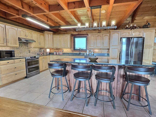 kitchen featuring a center island, a breakfast bar, refrigerator, and electric range