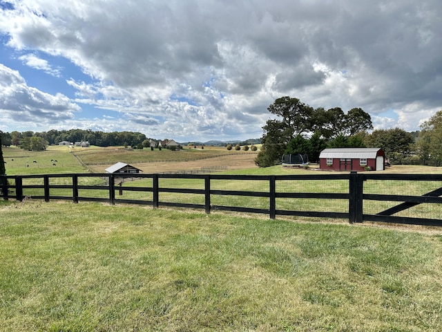 view of yard with a rural view and an outdoor structure