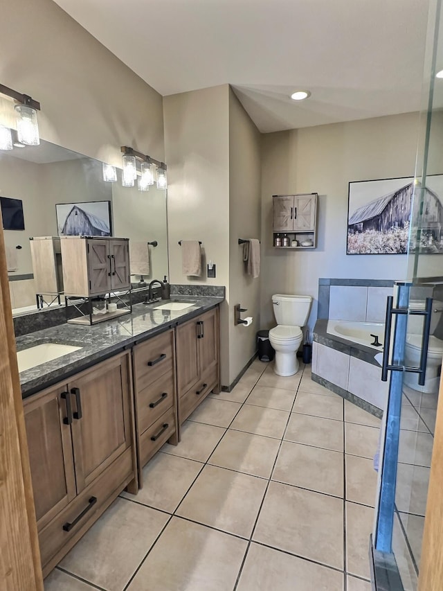 bathroom featuring tile patterned floors, a bathtub, toilet, and vanity