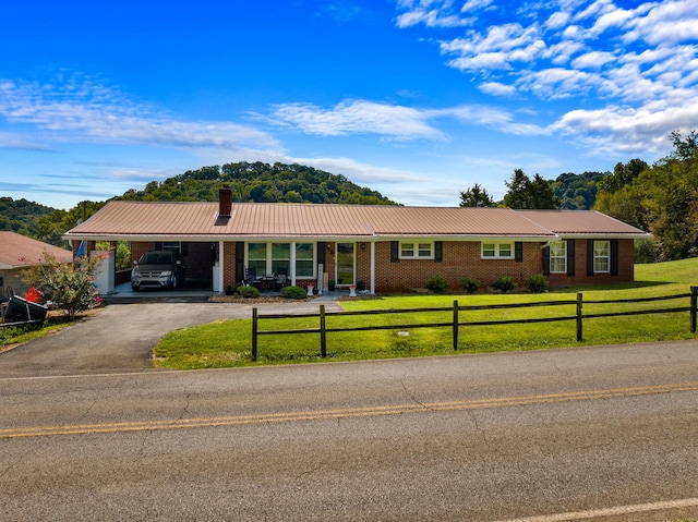 ranch-style house featuring a front lawn and a carport