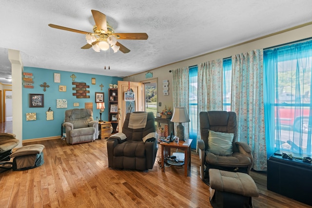 living room featuring hardwood / wood-style flooring, ceiling fan, a textured ceiling, and a wealth of natural light