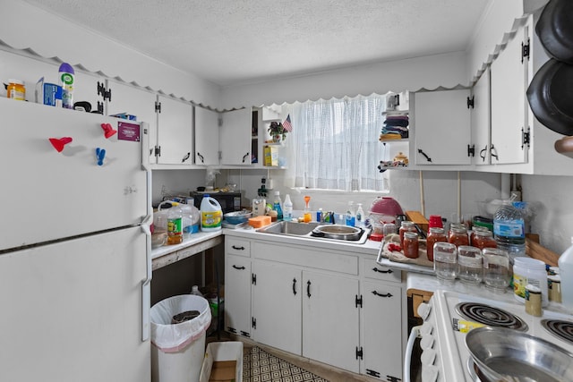 kitchen with a textured ceiling, white appliances, white cabinetry, and sink