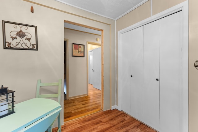 office space featuring a textured ceiling, light wood-type flooring, and crown molding