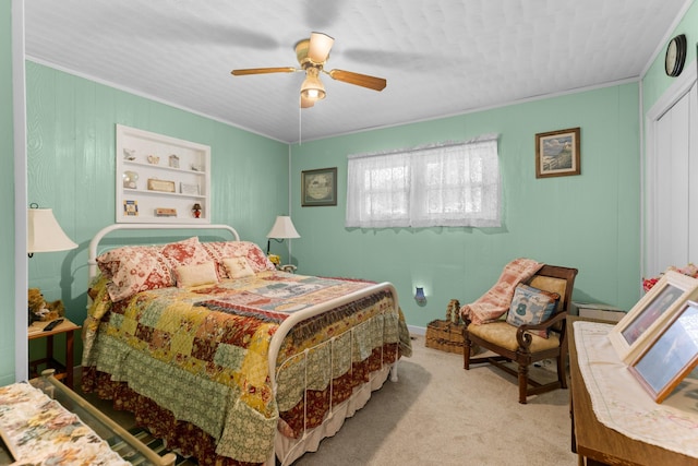 carpeted bedroom with ceiling fan and ornamental molding