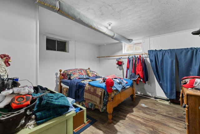 bedroom with wood-type flooring and a textured ceiling