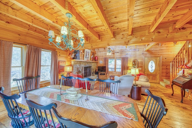 dining space featuring light hardwood / wood-style floors, a wealth of natural light, wood ceiling, and wood walls