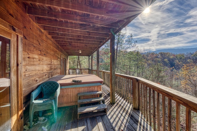 wooden deck with a covered hot tub