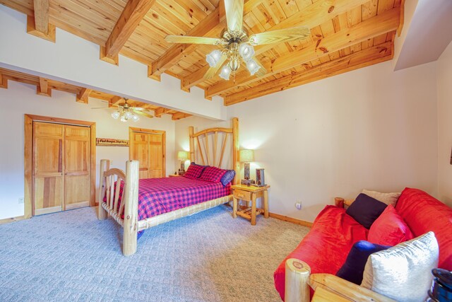 carpeted bedroom featuring multiple closets, beam ceiling, wooden ceiling, and ceiling fan