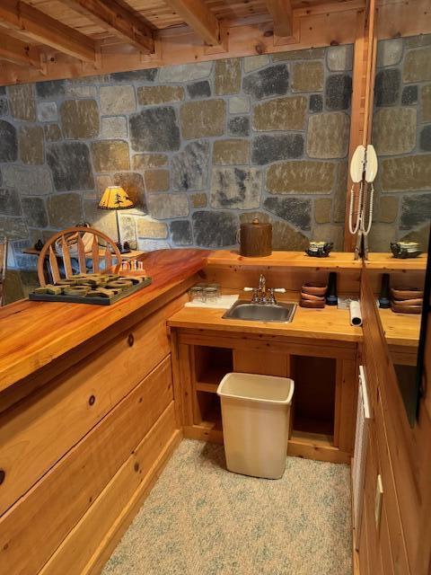 interior space with indoor wet bar, wood ceiling, and beamed ceiling