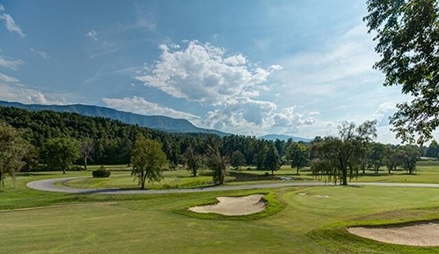 surrounding community with a mountain view and a yard