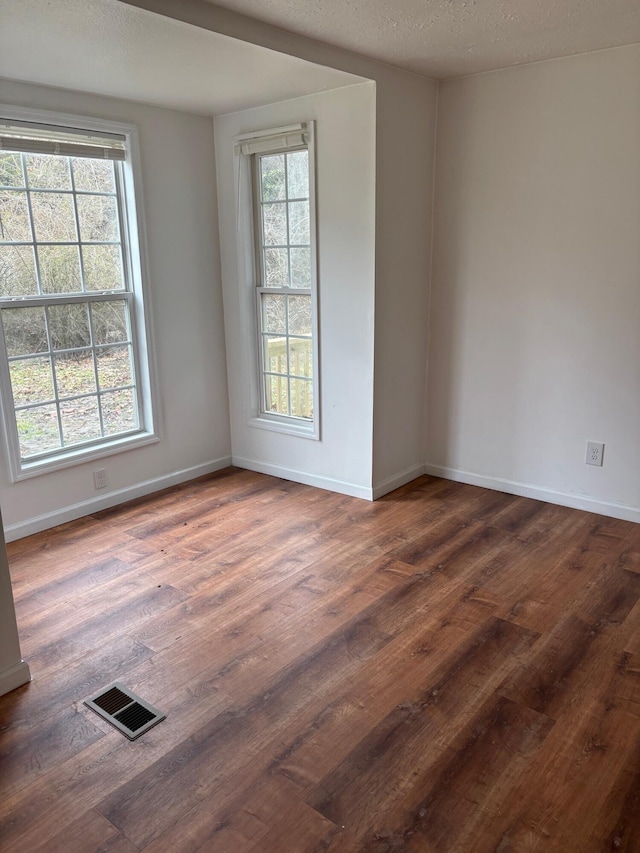 empty room featuring dark hardwood / wood-style flooring and a textured ceiling