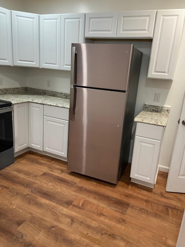 kitchen featuring white cabinetry, light stone counters, dark hardwood / wood-style flooring, and stainless steel appliances