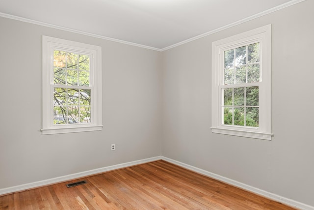 empty room with light wood-type flooring and ornamental molding