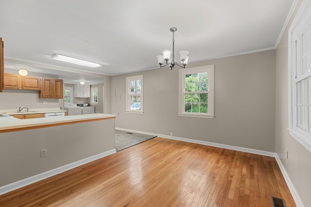 kitchen with separate washer and dryer, light hardwood / wood-style flooring, crown molding, a chandelier, and decorative light fixtures