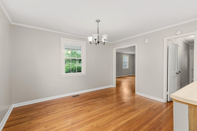 unfurnished room featuring a notable chandelier, crown molding, and light hardwood / wood-style flooring