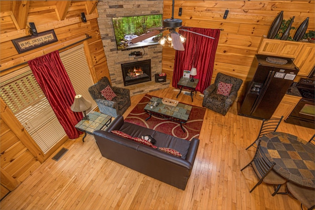 2040 Cougar Crossing Way, Sevierville, TN 37862 - living room with a fireplace, wood-type flooring, visible vents, and wooden walls