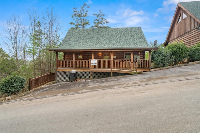 2040 Cougar Crossing Way, Sevierville, TN 37862 - log-style house featuring covered porch, roof with shingles, log exterior, and concrete driveway