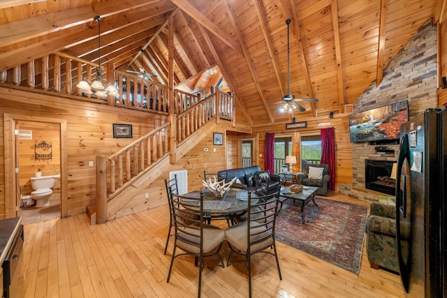 2040 Cougar Crossing Way, Sevierville, TN 37862 - unfurnished dining area with a stone fireplace, wood walls, wood-type flooring, and a ceiling fan