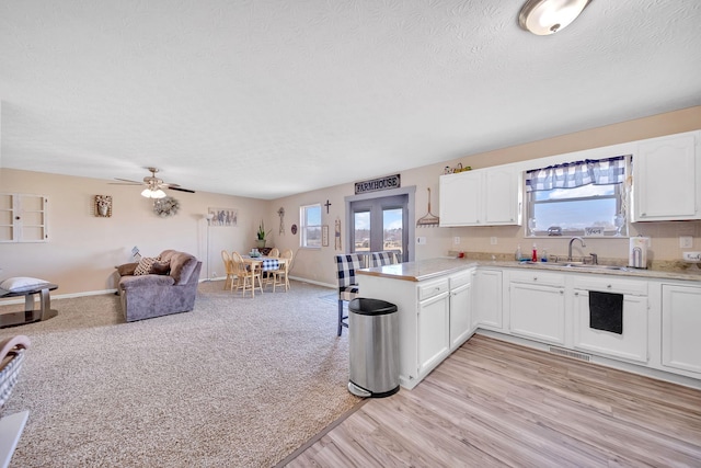 1439 Woods Ridge Rd, Dandridge, TN 37725 - kitchen with healthy amount of natural light, white cabinets, light countertops, open floor plan, and a textured ceiling