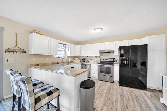 1439 Woods Ridge Rd, Dandridge, TN 37725 - kitchen featuring stainless steel appliances, under cabinet range hood, a peninsula, white cabinetry, and light countertops