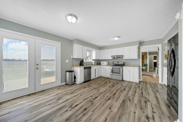 1439 Woods Ridge Rd, Dandridge, TN 37725 - kitchen featuring appliances with stainless steel finishes, light wood-style floors, light countertops, french doors, and a textured ceiling