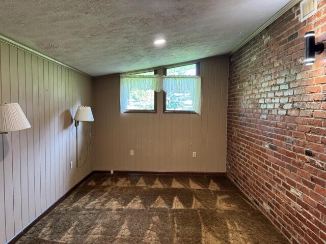 2414 Woodchuck Dell, Morristown, TN 37814 - unfurnished room featuring dark colored carpet, a textured ceiling, and wooden walls