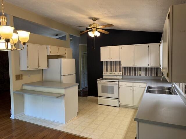 2414 Woodchuck Dell, Morristown, TN 37814 - kitchen featuring white appliances, vaulted ceiling, a ceiling fan, white cabinetry, and a chandelier