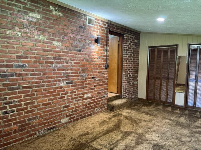 2414 Woodchuck Dell, Morristown, TN 37814 - unfurnished living room featuring carpet floors, a textured ceiling, and brick wall