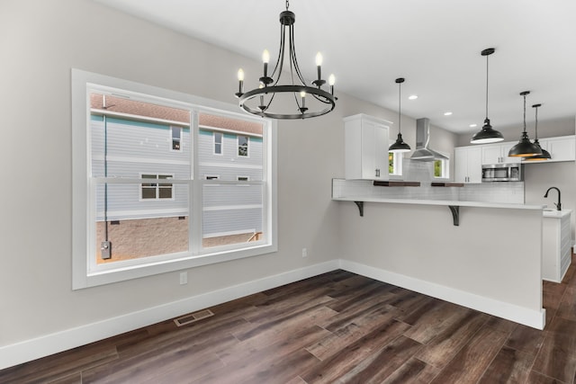 274A W Main St, Dandridge, TN 37725 - kitchen with wall chimney exhaust hood, stainless steel microwave, a chandelier, a kitchen bar, and backsplash