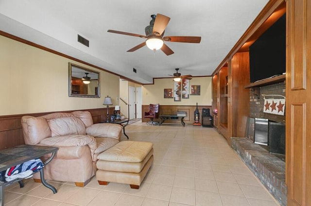 591 Phyllis Cir, Talbott, TN 37877 - living room featuring a fireplace, ceiling fan, light tile patterned floors, crown molding, and wood walls