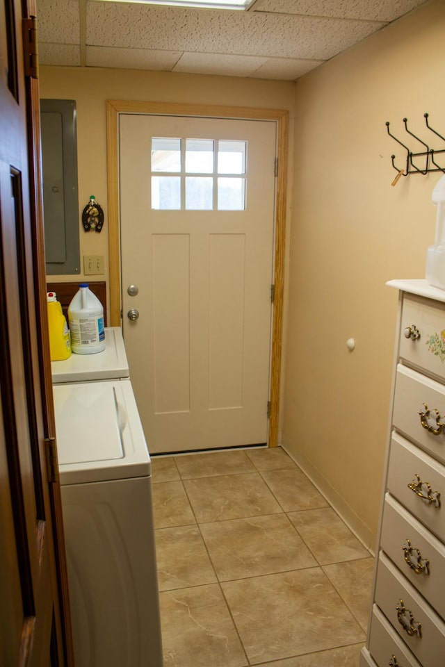 washroom featuring electric panel, washing machine and dryer, and light tile patterned floors